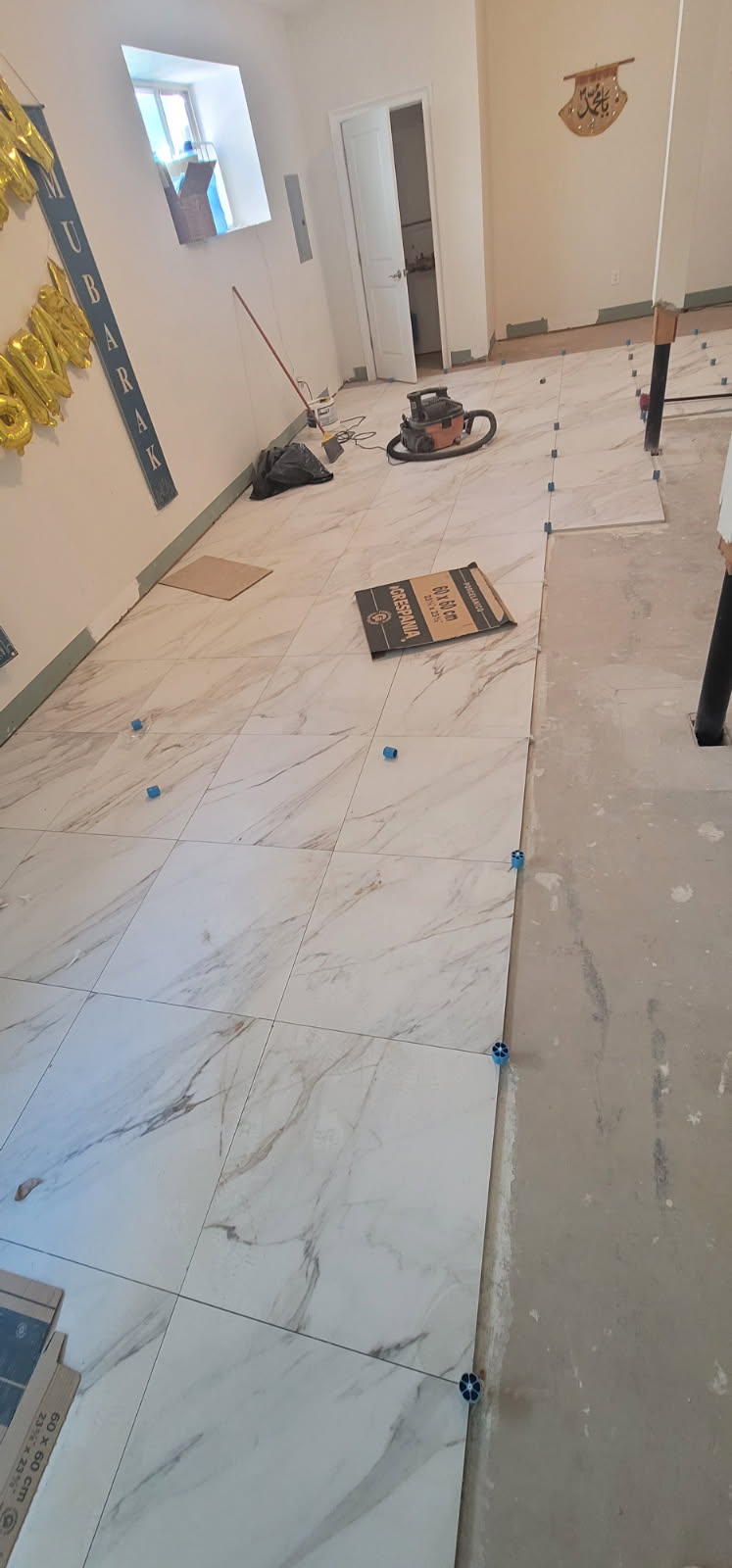Marble tile flooring being laid with leveling spacers